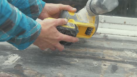 Attaching-a-charged-battery-to-an-orbital-sander