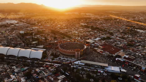 Drone-shot-approaching-the-Plaza-de-Toros-stadium,-sundown-in-Mexico---Aerial-view
