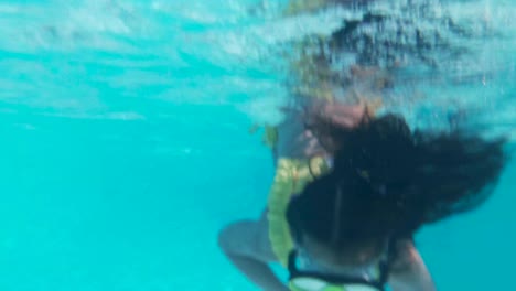 Happy-girl-in-goggles-swim-underwater-in-pool.-Close-up.