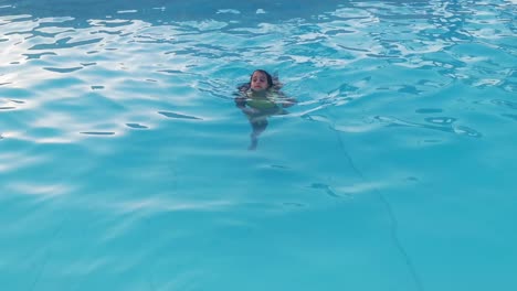 smiling-girl-in-swimming-pool,-child-is-playing.-Summer-vacation-or-classes.-Summertime-and-swimming-activities-for-happy-children-on-the-pool.