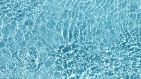 Water-surface-texture,-Slow-motion-clean-swimming-pool-ripples-and-wave,-Refraction-of-sunlight-top-view-texture-sea-side-white-sand,-sun-shine-water-background.-Water-Caustic-Background