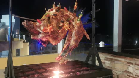 The-meat-is-fried-on-a-grill-on-a-spit.-The-ram-is-fried-on-a-spit-on-an-open-fire-in-a-restaurant.