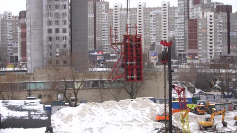 aerial-top-view-of-city-construction-site.-tower-cranes-for-building-of-new-apartments-under-snow-in-winter