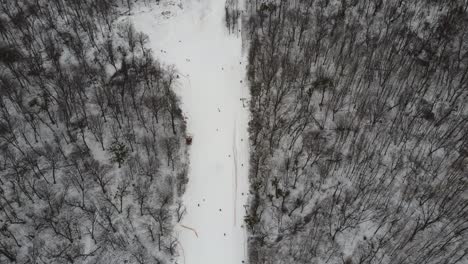 Skifahrer-Und-Snowboarder-Fahren-Am-Wochenende-Auf-Schneepisten-Mit-Skilift.-Drohne-Fliegt-An-Einem-Frostigen-Wintertag-Mit-Skifahrern-Und-Snowboardern-über-Verschneiten-Hang-Im-Skigebiet:-Drohnenansicht