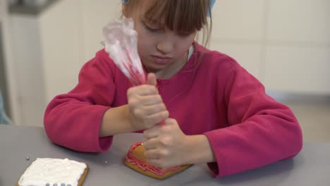 Close-up-view-of-kids-hands-decorating-homemade-cookies-for-holidays.-A-child-decorates-cookies-pressing-out-fondant-or-paste-from-a-tube