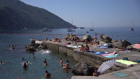 People-sunbathe-and-play-water-activities-in-a-charming-and-tranquil-atmosphere-at-the-famous-spot-of-Camogli-Beach-in-the-Liguria-region-of-Italy