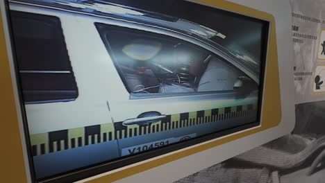 Ein-Kleiner-Fernsehmonitor-Im-Automobilmuseum,-Der-Einen-Autounfalltest-Mit-Schaufensterpuppe-Und-Airbag-Zeigt
