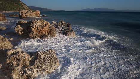 Big-waves-splashing-and-foaming-on-cliffs-plunged-on-beach,-dramatic-sea-scene-on-shoreline-of-Mediterranean