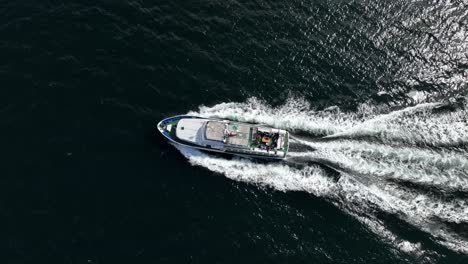 Privates-Touristencharterboot,-Das-Am-Sognefjord-In-Norwegen-Segelt-–-Luftaufnahme,-Die-Sich-Nach-Oben-Bewegt-Und-Sich-Nach-Unten-Neigt,-Um-Eine-Vogelperspektive-über-Dem-Boot-Mit-Menschen-Auf-Dem-Achterdeck-Zu-Ermöglichen
