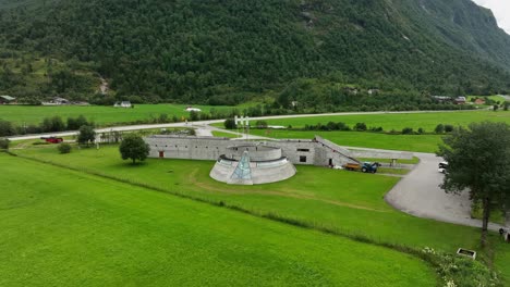 Fjaerland-Glacier-museum-and-exhibition-in-Sogn---Orbit-aerial-around-design-award-winning-building-with-tourists-standing-on-top-during-summer-in-Norway---60-fps
