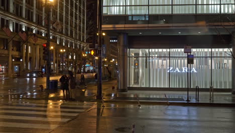 People-walking-over-crossroads-at-the-Zara-store,-night-in-downtown-Chicago