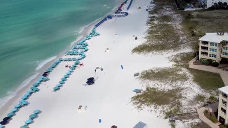 Aerial-video-of-Silver-Dunes-Condominiums-Beachfront-Resort,-Destin,-Florida,-United-States-and-coastline-with-colorful-beach-chair,-umbrellas,-clouds-blue-sky,-Aerial-view-Henderson-beach-state-park