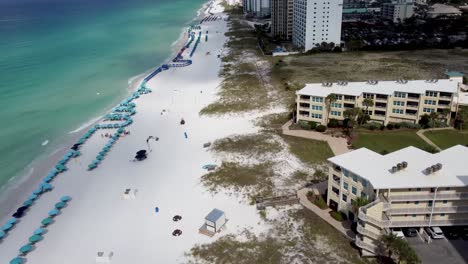 Aerial-view-of-Silver-Dunes-Condominiums-Beachfront-Resort,-Destin,-Florida,-United-States-and-coastline-with-colorful-beach-chair,-umbrellas,-clouds-blue-sky,-Aerial-view-Henderson-beach-state-park