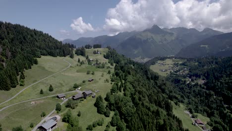 Französische-Alpen,-Berghangwiesen-Und-Tal-Oberhalb-Des-Dorfes-Les-Gets-Im-Sommer-Mit-Hohen-Berggipfeln-Im-Hintergrund,-Umgeben-Von-Wolken