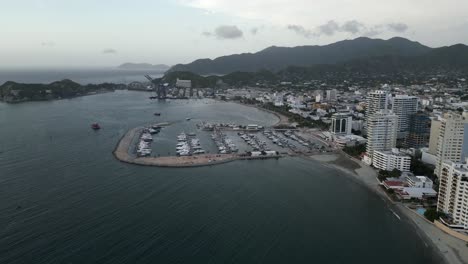 Santa-Marta-Colombia-Mar-Caribe-Océano-Drone-Vista-Aérea-Rodadero-Hotel-Rascacielos-Construyendo-Un-Puerto-Con-Barco