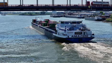 Aerial-View:-"AMAZONE"-Blue-River-Cargo-Boat-Passes-Under-Traffic-Clogged-Bridge