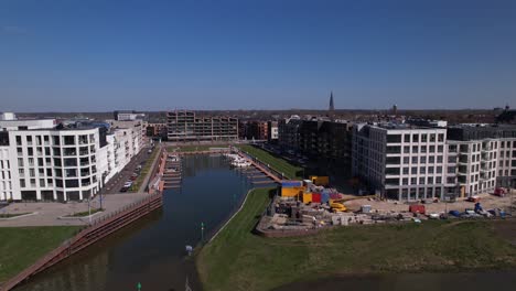 Sideways-pan-and-reveal-of-Kade-Zuid-modern-apartment-complex-at-recreational-port-Noorderhaven-showing-wider-cityscape