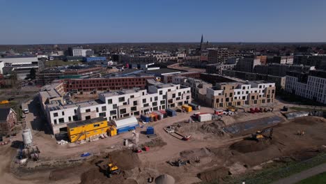 Meadow-floodplains-and-aerial-view-on-PUUR21-new-housing-construction-project-part-of-urban-development-in-Zutphen-with-Noorderhaven-neighbourhood-along-river-IJssel-preparatory-lot-of-PRACHT-towers