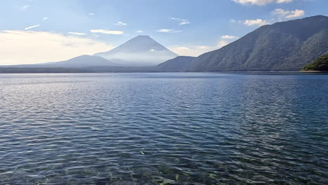 Majestic-Mount-Fuji-overlooks-the-shimmering-expanse-of-Lake-Motosu,-a-tranquil-and-breathtaking-scene