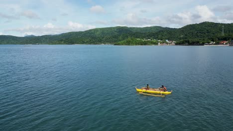 Sencillos-Pescadores-En-Un-Barco-De-Madera-Remando-En-El-Océano,-Costa-Filipina