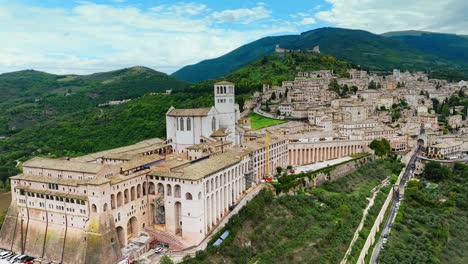 Flying-Towards-The-Basilica-of-Saint-Francis-of-Assisi,-Famous-Hillside-Catholic-Church-In-Assisi,-Italy