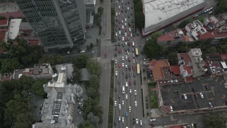 City-aerial-tracks-vehicle-traffic-on-multi-lane-street-in-modern-city