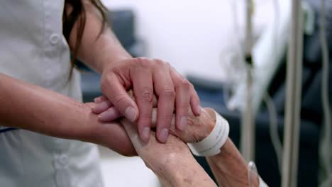 Female-woman-holding-hand-of-senior-grandmother-patient,-closeup-view