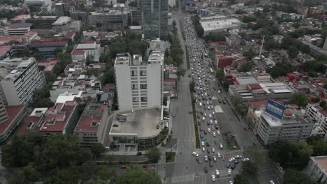 Downtown-urban-aerial-tilts-to-reveal-traffic-on-Mexico-City-street