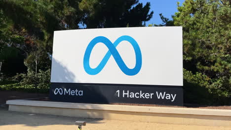 Panning-shot-to-close-up-meta-sign-at-1-hacker-way-entrance-to-platform-headquarters-in-Menlo-park,-California