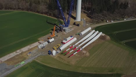 Blades-Of-A-Windmill-On-The-Ground,-Wind-Turbine-Construction---aerial-shot-arc