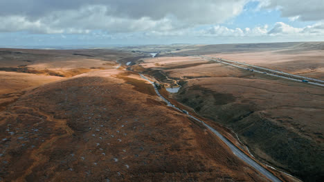 Aerial-drone,-cinematic-footage-of-a-country-winding-road-on-Saddleworth-Moor,-Greater-Manchester,-UK