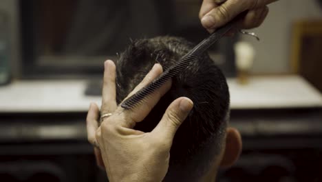 Close-Up-Of-Barber-Cutting-Client's-Hair-At-Barbershop