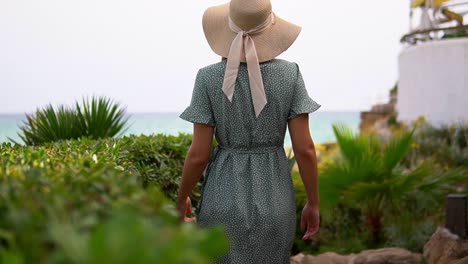 Stunning-video-of-a-caucasian-girl-wearing-a-knitted-hat-and-beautiful-green-dress-walking-to-the-beach-de-la-Pillisseta-and-admiring-the-breathtaking-view