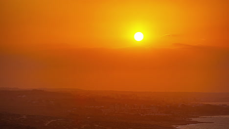 Un-Sol-Amarillo-Brillante-Emerge-De-Un-Resplandor-Naranja-Detrás-De-Las-Nubes