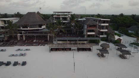 Amansala-hotel-resort,-aerial-view-of-pool-and-living-area-with-sunbeds-and-palm-trees
