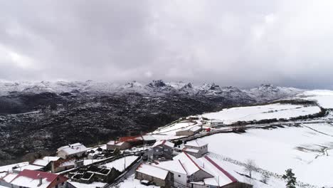 Village-with-snow-capped-mountains-Aerial-View