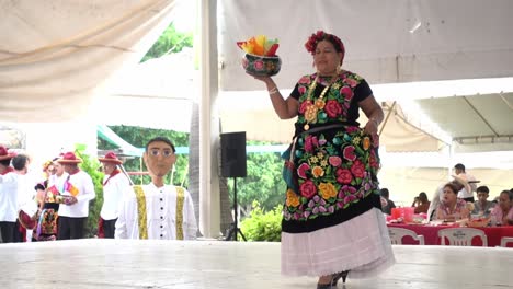 Slow-motion-shot-of-a-Mexican-woman-walking-around-the-stage-carrying-gifts-at-the-guelaguetza