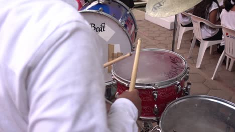 Slow-motion-over-the-shoulder-shot-of-a-drummer-beating-his-drum-keeping-time