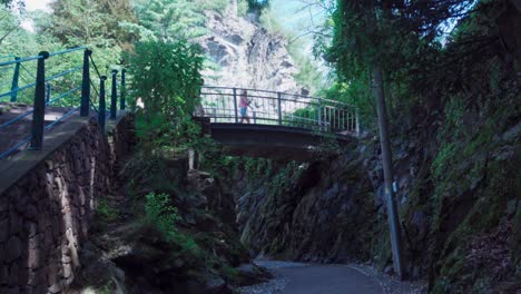 Gente-Caminando-A-Través-Y-Debajo-Del-Puente-Peatonal-En-El-Desfiladero-De-Gilf-En-Meran,-Tirol-Del-Sur,-Italia