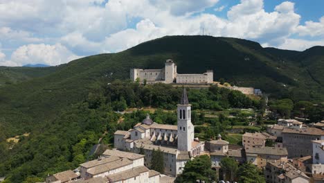 Vista-Aérea-Del-Campanario-De-La-Catedral-De-Spoleto-Con-Rocca-Albornoziana-Al-Fondo-En-La-Cima-De-Una-Colina