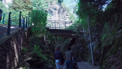 People-walking-across-and-below-the-footbridge-at-the-Gilf-Gorge-in-Meran,-South-Tyrol,-Italy