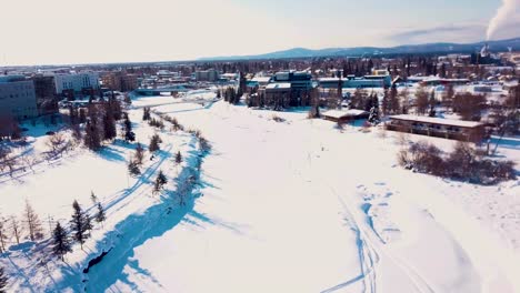 Video-De-Drones-De-4k-Del-Río-Chena-Congelado-En-El-Centro-De-Fairbanks,-Alaska,-En-Un-Día-Nevado-De-Invierno