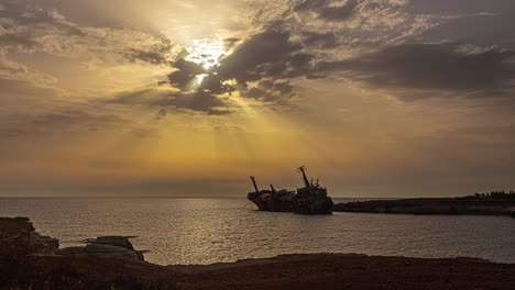 Timelapse-Reveals-Edro-III-Shipwreck-Amid-Sunrise's-Radiance-and-Beams-of-Light-Piercing-Through-Clouds
