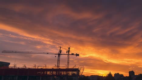 spectacular-and-colorful-sunset-with-clouds-in-a-city-with-constructions-works-as-foregorund-cranes-and-scaffoldings