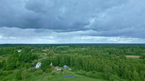 Aerial-drone-tilt-up-shot-over-village-houses-surrounded-by-lush-green-vegetation-on-a-cloudy-day