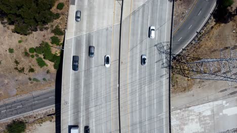 Birds-eye-view-drone-shot-cars-driving-on-freeway-overpass-in-California