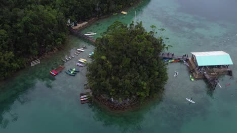 People-surfing-and-kayaking-on-famous-Siargao-Island-surrounded-by-tropical-rainforest,-Philippines