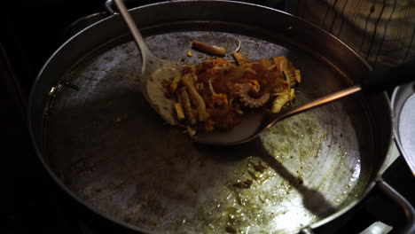 Ein-Koch-Bereitet-In-Einer-Großen-Edelstahlpfanne-Einen-Traditionellen-Thailändischen-Oktopus-Zu