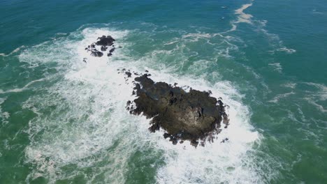 Ocean-waves-and-rocky-coral-island,-aerial-orbit-view