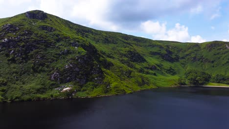Aerial-Side-Panning-Shot-of-a-Gorgeous-Mountain-Lake-and-Green-Mountains-in-Ireland